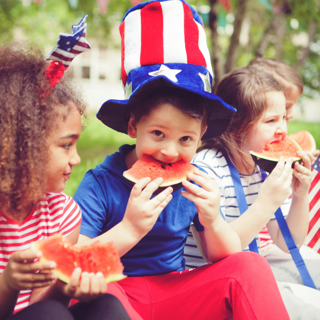 3 kids celebrating 4th of july eating watermelon