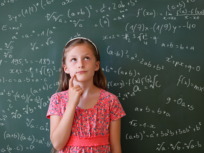Girl thinking in front of complicated math problems on chalkboard