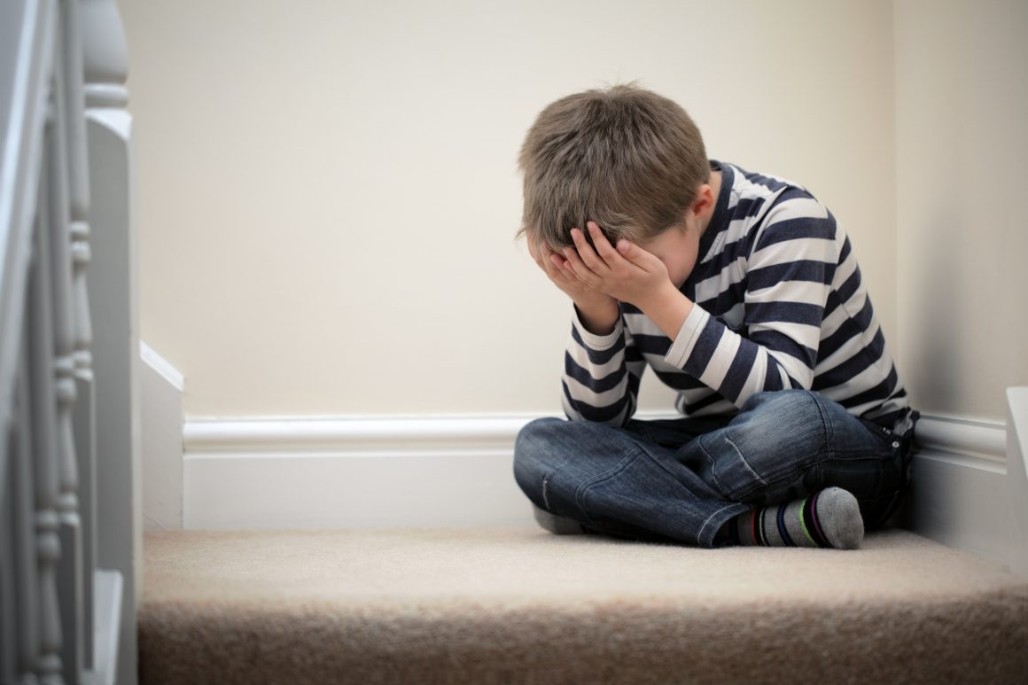 Boy crying on the stairs